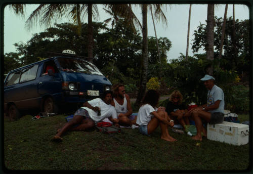 People seated on the grass possibly during filming of Blue Lagoon 2