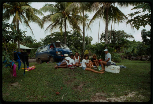 People seated on the grass possibly during filming of Blue Lagoon 2