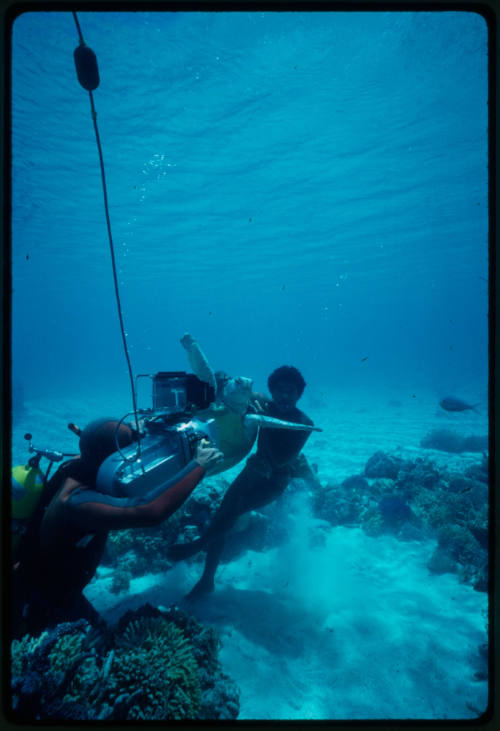 Filming of a boy holding a turtle underwater