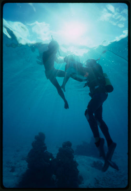 Diver filming an underwater scene with a boy