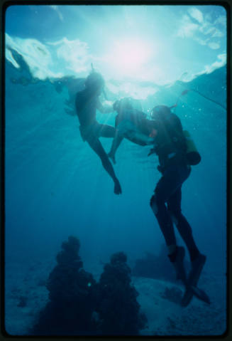 Diver filming an underwater scene with a boy