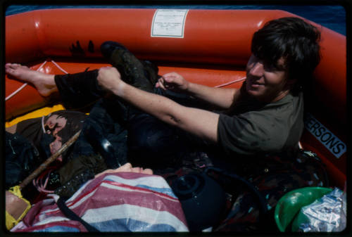 Actor in an inflatable raft next to a dummy corpse