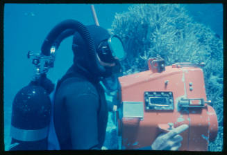 Diver holding a large orange underwater camera