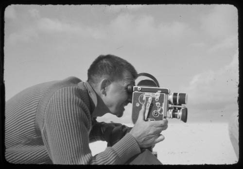 Black and white side angle portrait shot a man looking through a camera