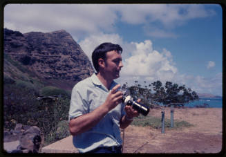 Lanscape side portrait of Ron Taylor holding a camera in Hawaii