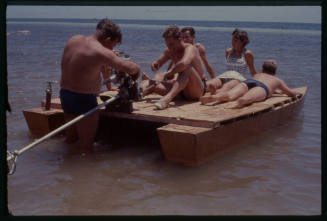 Six people on a simple wooden boat