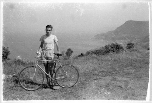 Man posing with bicycle at a coastal lookout point