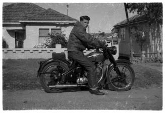 Man posing on a motorbike in a suburban street