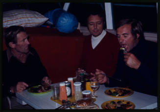 Three men eating at a dining table