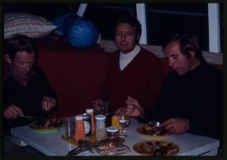 Three men eating at a dining table
