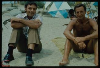 Ron Taylor sitting next to another man on the beach