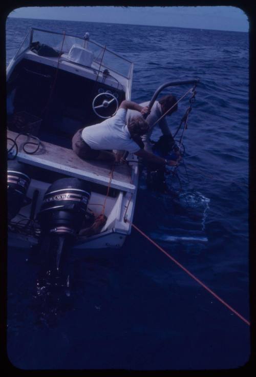 Crew lowering a shark cage into the water during the filming of "Jaws"