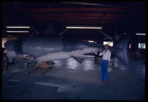 Valerie Taylor standing next to the large scale great white shark model used in "Jaws"