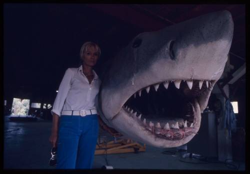 Valerie Taylor standing next to large scale great white shark model used in the filming of "Jaws"