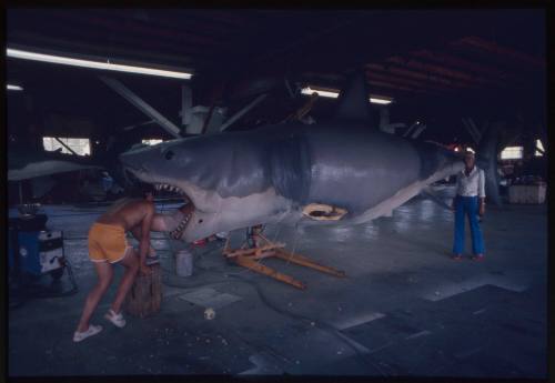 Three people with large great white shark model made for filming of "Jaws"