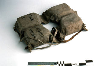 Life jacket with four foam sections covered in canvas with two canvas ties to secure at waist from the tug ILUKA