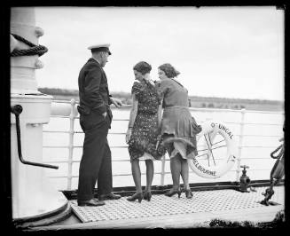 Two women and a ship's officer on the deck of SS ORUNGAL