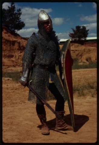 Person in medieval chainmail suit costume, part of the inspiration of Ron and Valerie Taylor's chainmail scuba diving suit used for working with wild animals underwater, namely sharks. 