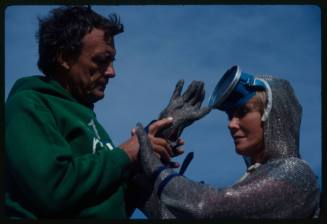 Ron Taylor assisting Valerie Taylor to put on left glove of mesh suit