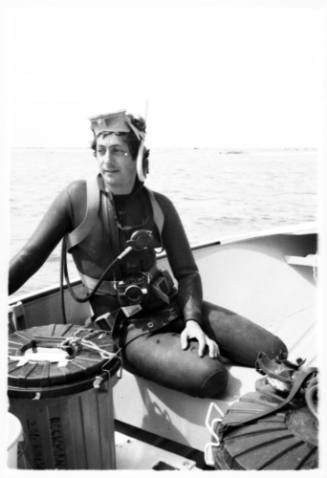 Shot of diver with camera attached sitting on board boat sea