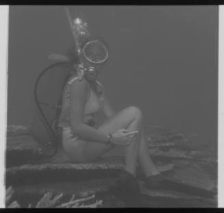 Underwater shot of scubadiver sitting on coral bed