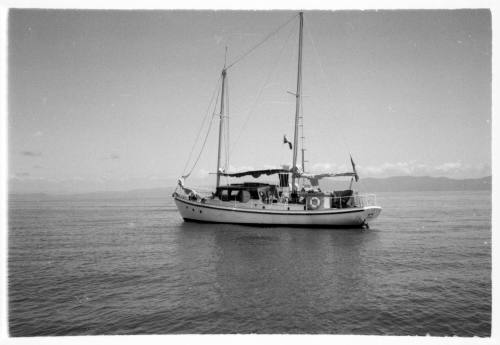 Black and white shot of yacht at sea on still waters with the sails down