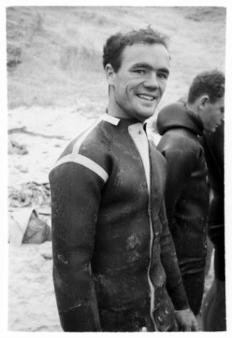 Black and white  Medium shot of person in wetsuit with others in background