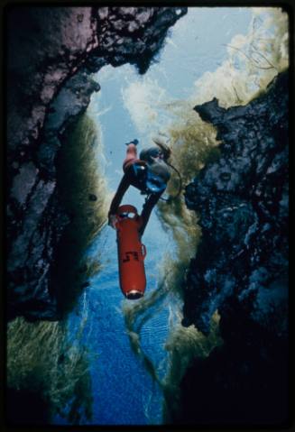 Valerie Taylor making way into underwater crevice