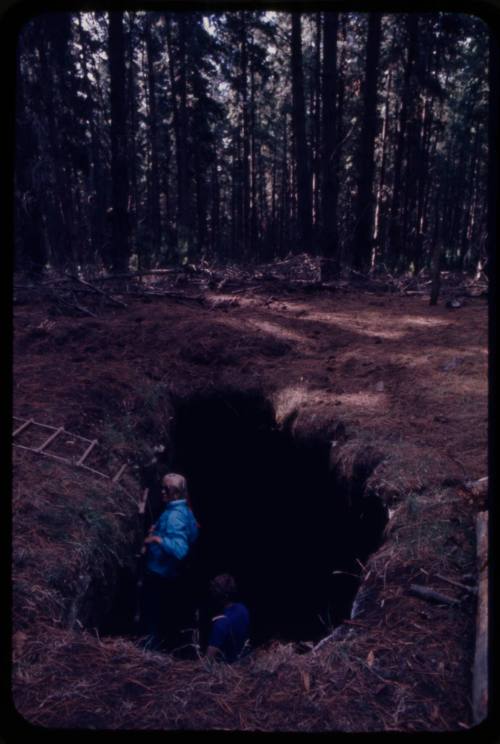 Valerie Taylor on a rope ladder leading down into hole in ground