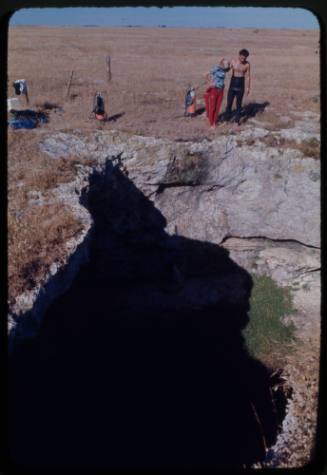 Valerie and Ron Taylor looking down into hole in ground