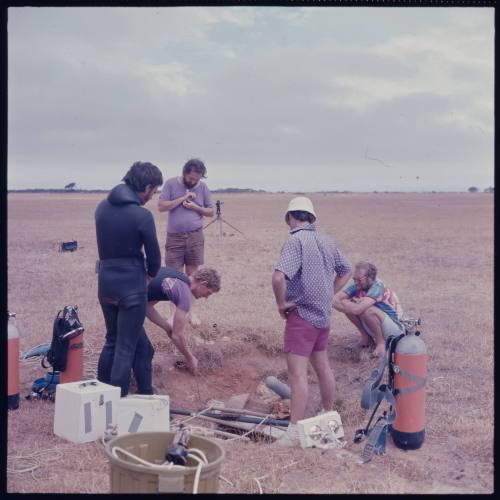 Five people near a hole in ground