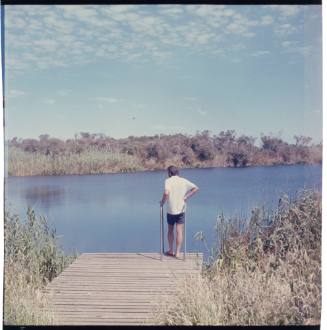 Man standing on a platform at edge of body of water