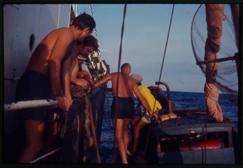 Two vessels alongside each other with people on board including Peter Lake