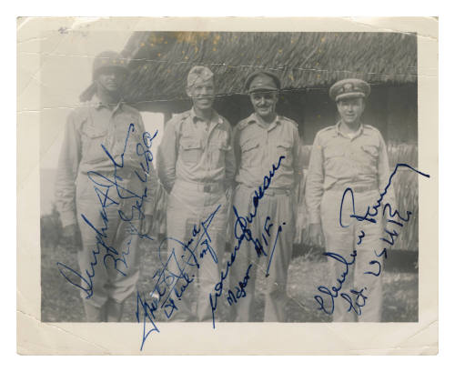 Four men in uniform smiling at the camera