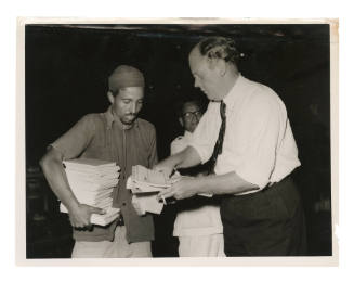 Officials with documents in association with arrival at Aden of survivors from the sinking of the MV SKAUBRYN