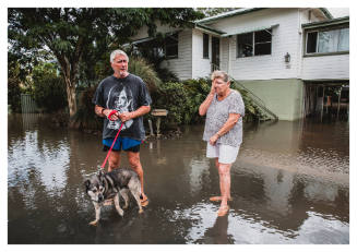 People and a dog on a flooded street