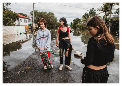 Three girls on a flooded road