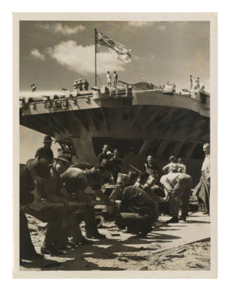 Civilian dock workers hauling in a Royal Navy aircraft carrier at Garden Island Naval Dockyard, Sydney Harbour