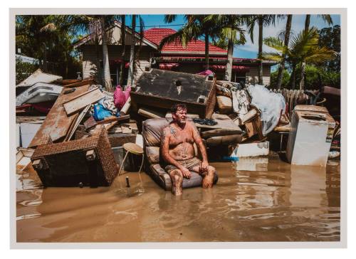 Man seated on a sofa in flood water