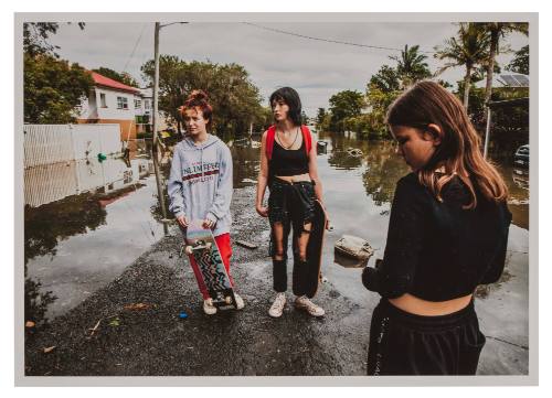 Three girls on a flooded road