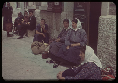 People seated on a street in Trieste