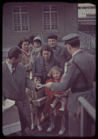 People having tickets checked by an official before embarkment