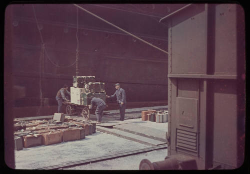 Three men loading luggage on to SS TOSCANA