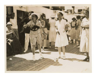 Two women playing quoits on a crowded deck