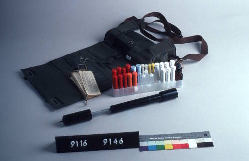 PHIAL WITH FLIP TOP CONTAINING THIRTEEN AIR SAMPLING FILTERS, RED PLASTIC WITH A WHITE PLASTIC BASE, THE FILTERS ARE OF CLEAR PLASTIC WITH CREAM FILTER PAPER