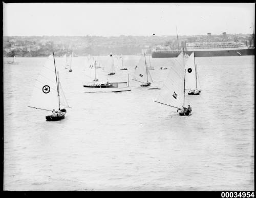 Regatta in harbour showing 12 small sailing boats.