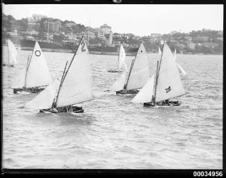 Image of a regatta with 7 sail boats in harbour.