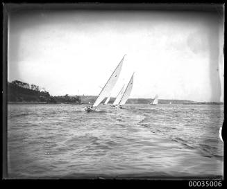 Stern view of four sailing boats racing in harbour