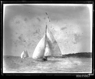 Two sailing boats underway in harbour bow on view.