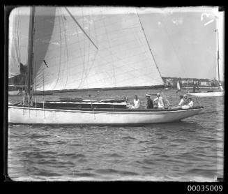 Starboard view of sailboat with seven people at stern